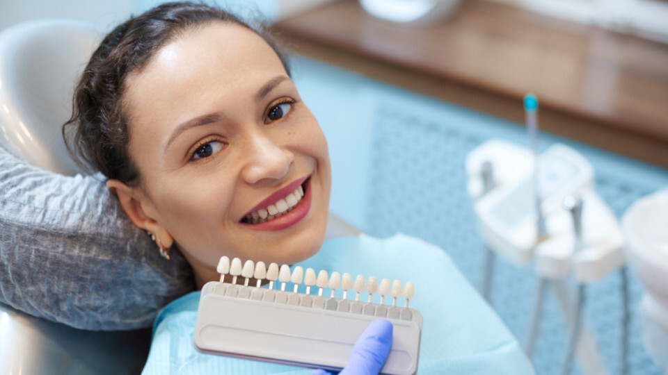 Eine Frau such die Farbe ihrer Veneers aus